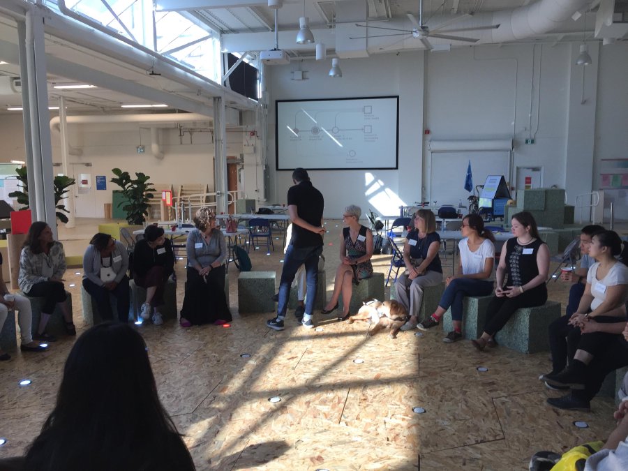 Participants at the Sidewalk Labs office sitting in a large circle on foam blocks on top of some dynamic streets prototype flooring