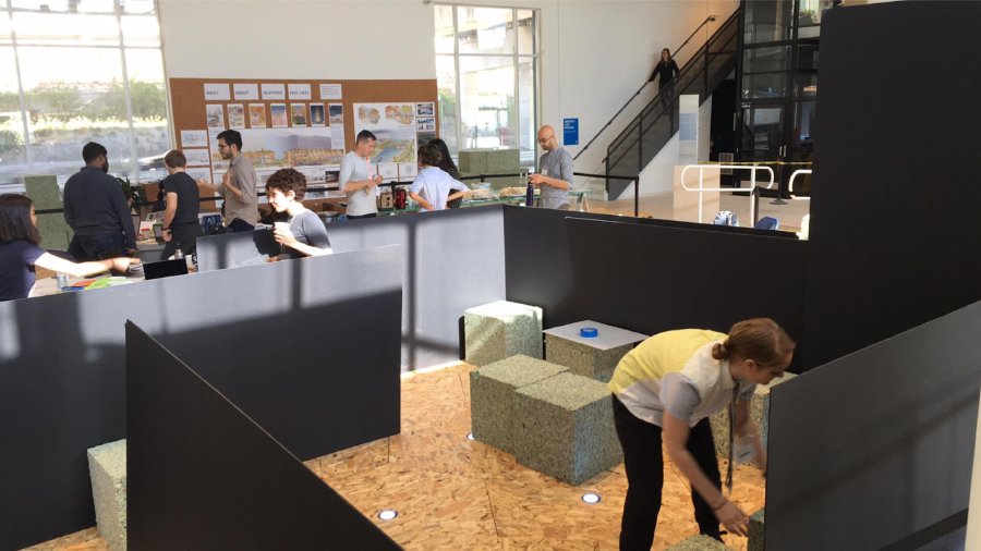 One participant arranging foam cubes inside the Tranquil Refuge model to build the interior seating area